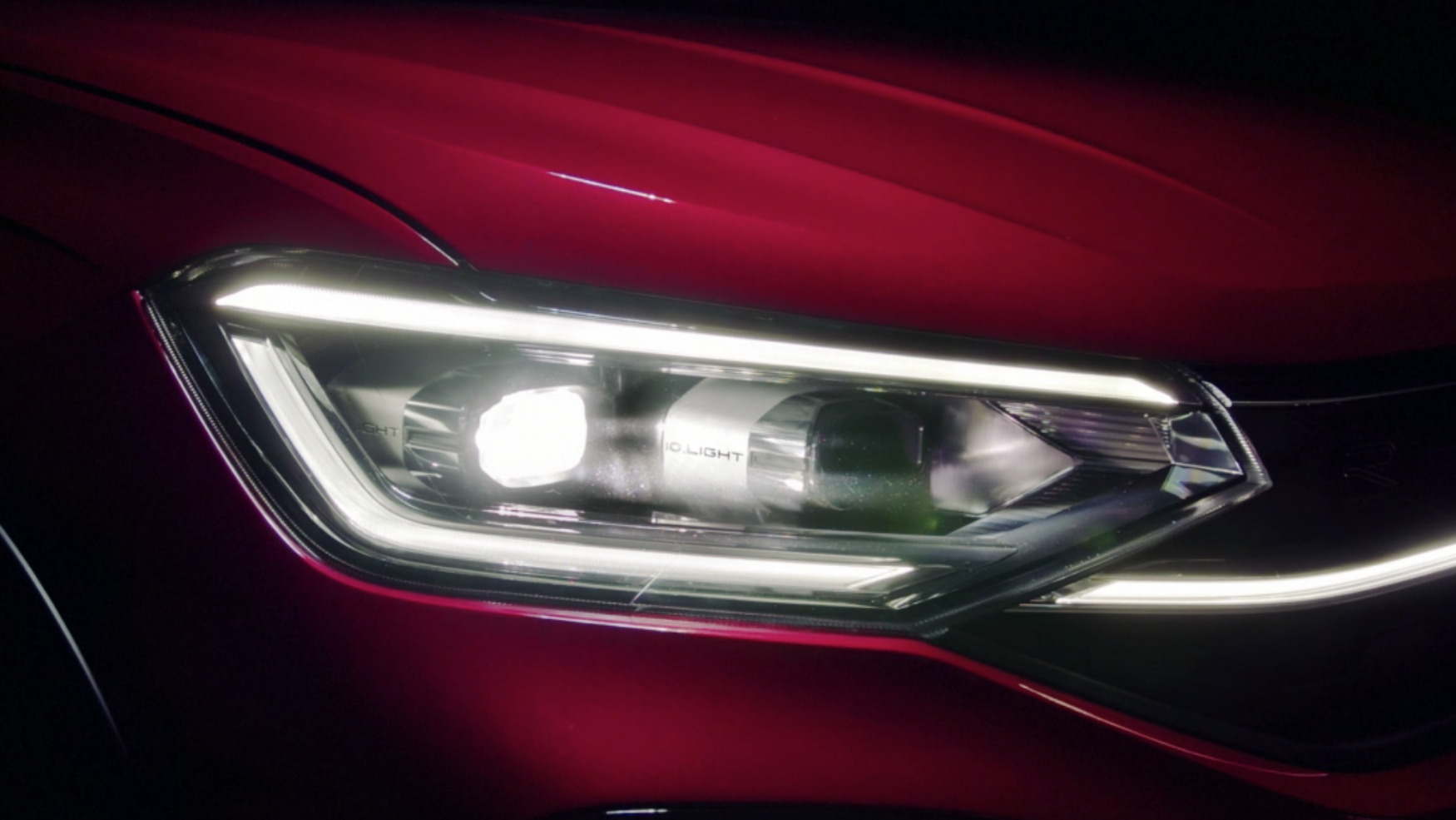 VW Taigo VW Taigo Style Front in Grün auf Parkplatz vor pinkem Gebäude